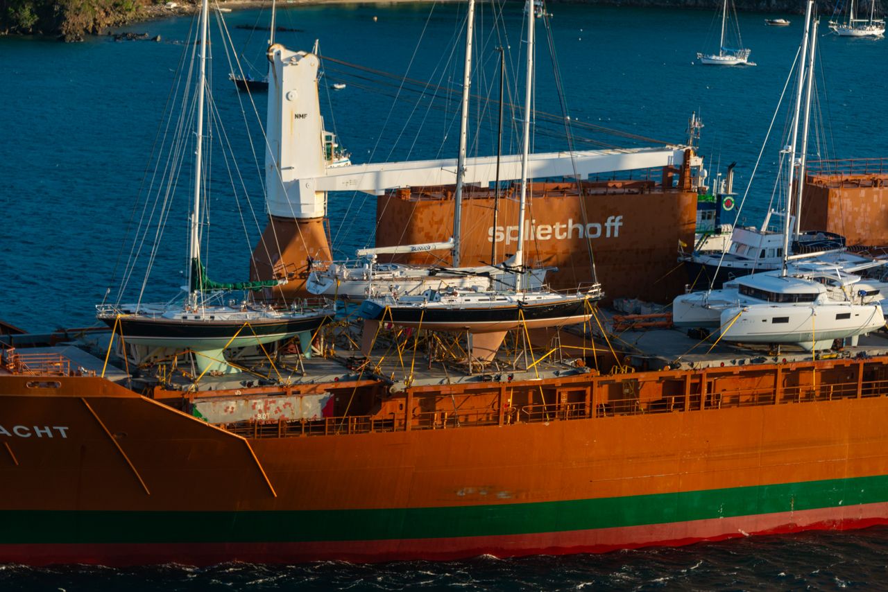 Aerial view of a cargo ship carrying sailboats across the ocean, showcasing marine transportation.